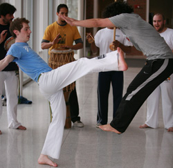 Junior Michael Walden (in light blue) and Professor Xara (in gray), a visiting professional from the Roots Capoeira Wellness Center in Des Moines, demonstrate Capoeria, which combines martial arts, music, and dance and originated in Brazil. Cornell's Capoeira Club provides instructional classes, brings professionals to campus, and participates in trips and events. (Photo by Andrew Decker '10)