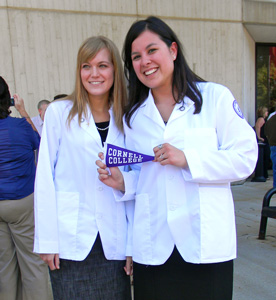 Kirsten Gierach '10 (left) and See-yin So '10 hold up a Purple Pennant after donning their white coats for the first time in a ceremony at Des Moines University's medical school. So came to Cornell because of the Dimensions progtam and is studying to become a physician. (Photo by See-yin So '10)