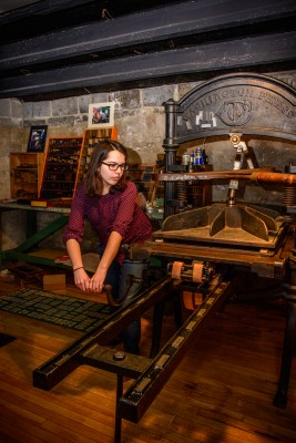 Cornell College  junior Laura Michelson using the college's 19th-century Washington letterpress.