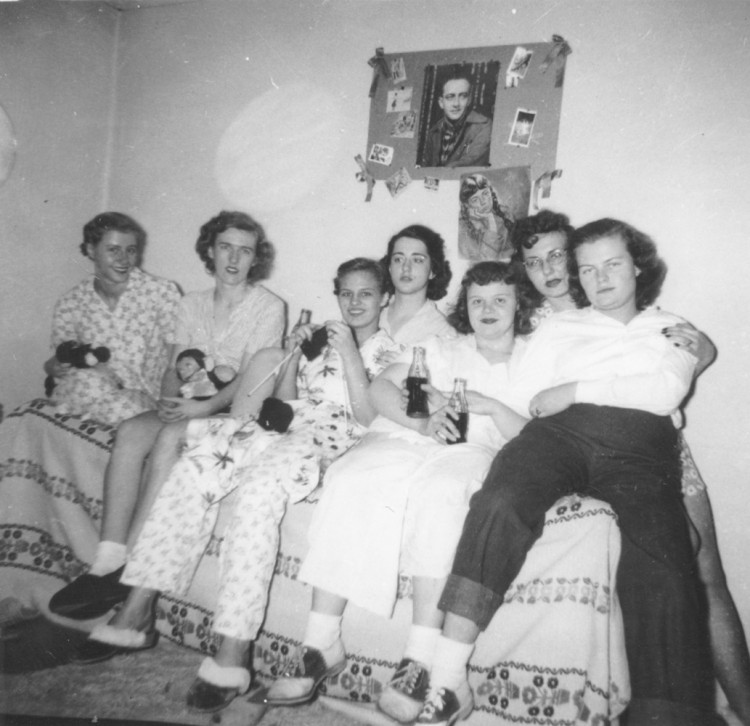 Helga Koch Konopacki ’50 (second from left) and her friends and roommates in Pfeiffer Hall enjoying Cokes and knitting. 