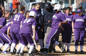 The Rams gather around sophomore Simone Wright as she crosses the plate on a home run against the University of Dubuque. 