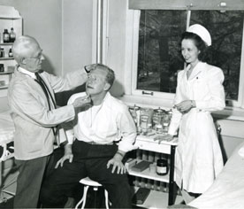 Dr. Francis Ebersole, Cornell's first official college physician, examines a student. He and his brother, Professor William Ebersole, left a joint bequest that funded Ebersole Health Center in 1955. (Photo courtesy of the Cornell Archives)