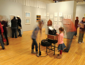 Xena (in motion using the pump) and Olive Fitzgerald, daughters of Professor Tony Plaut '78, use the "Typer Piper" at the exhibit opening. (Photo by Aaron Hall '10)