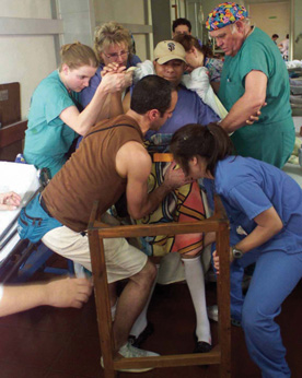 Dr. Larry Dorr '63 (top right) and Jamie Wallace '05 (left in green scrubs) assist a patient during Operation Walk in El Salvador in 2005. Wallace was one of the first students to participate in Operation Walk and is now in medical school at the University of Iowa where she was inducted into the Gold Humanism Honor Society. 
