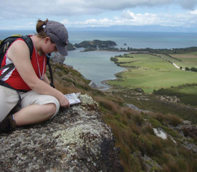 Megan Regel '08 maps structurally deformed rocks on a bluff overlooking Golden Bay at Cape Farewell, New Zealand. (Photo by Rhawn Denniston) 