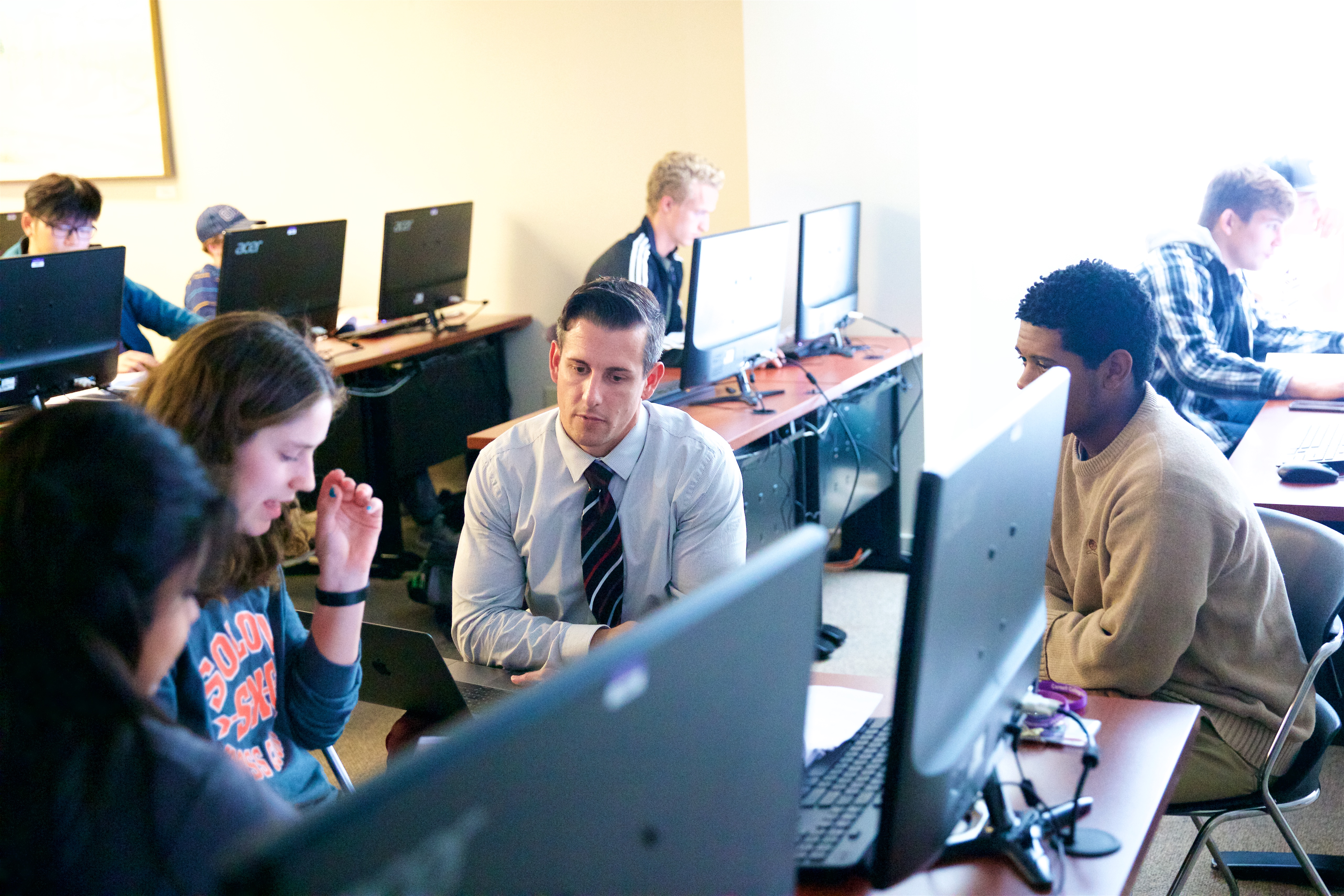 Professor of Engineering Brian Johns (center) consults with a student team designing a new type of dustpan. (Photo by Allan Recalde)