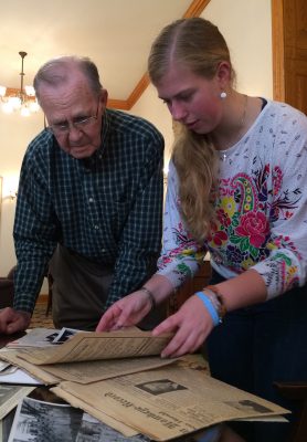 Hannah Robertson ’18 shares a WWII-era document from the Cornell archives with Darrell Gustaveson, who trained at Cornell’s Naval Flight Preparatory Academy in 1943. CREDIT: Dee Ann Rexroat ’82