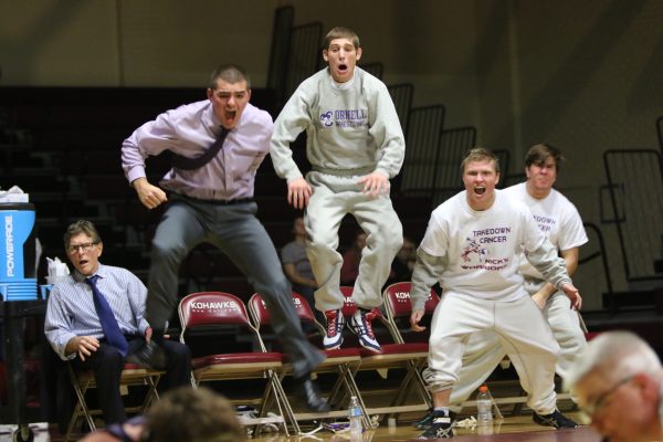 Wrestlers and coaches react to a victory over Coe
