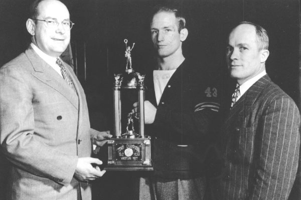 Cornell President Russell D. Cole, wrestler Dale "Whitey" Thomas and Coach Paul Scott with the 1947 NCAA championship trophy.