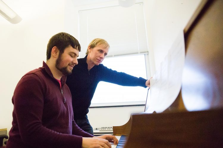 Composer in Residence Aaron Perrine works with a student.