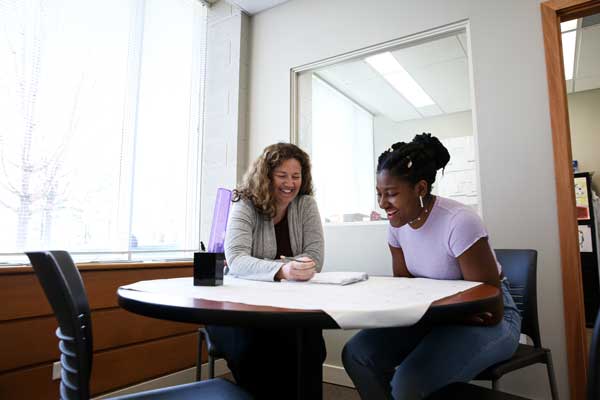 MkpoutoAbasi James worksk with staff in the Quantitative Reasoning Studio.