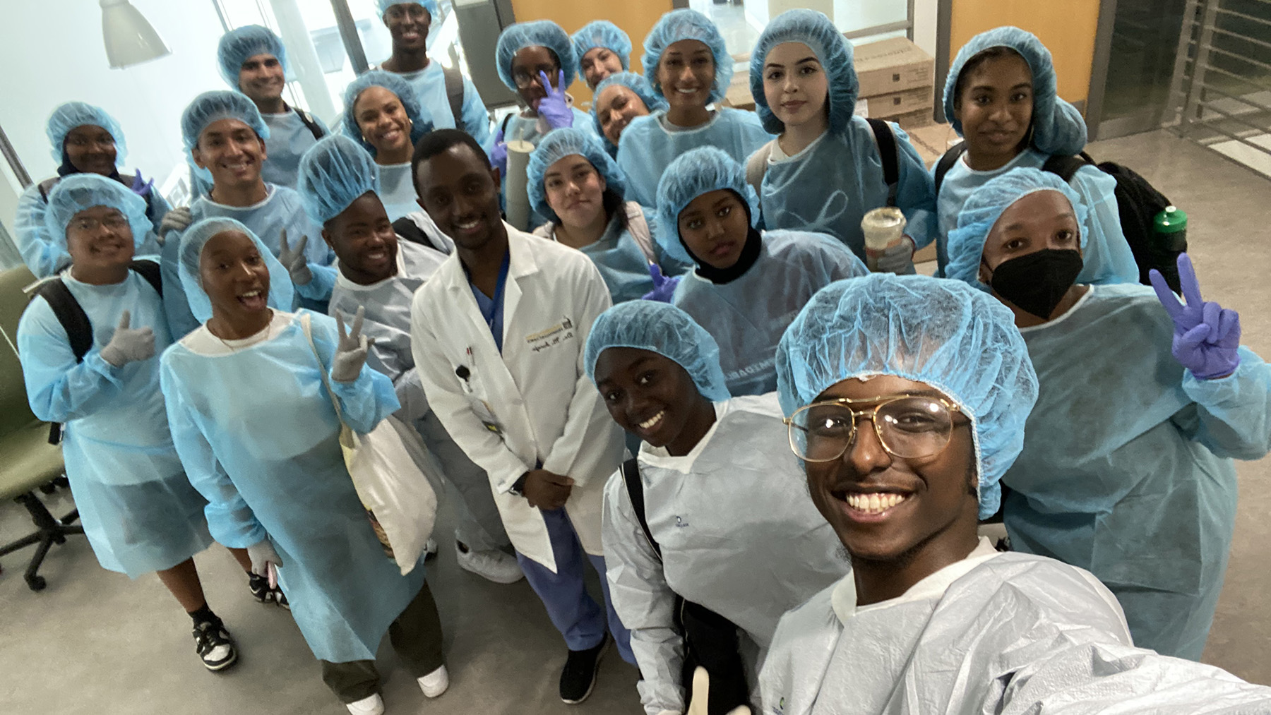 Said and his SHPEP medicine scholars celebrate their first workshop after they learned their introductory surgical skills: scrubbing in, gowning, and practicing laparoscopy techniques firsthand.