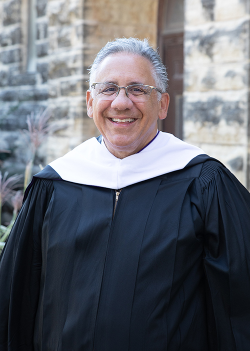 Ramos smiling for the camera with Convocation robe on.