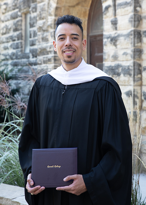 Diego smiling at the camera in his Convocation robe