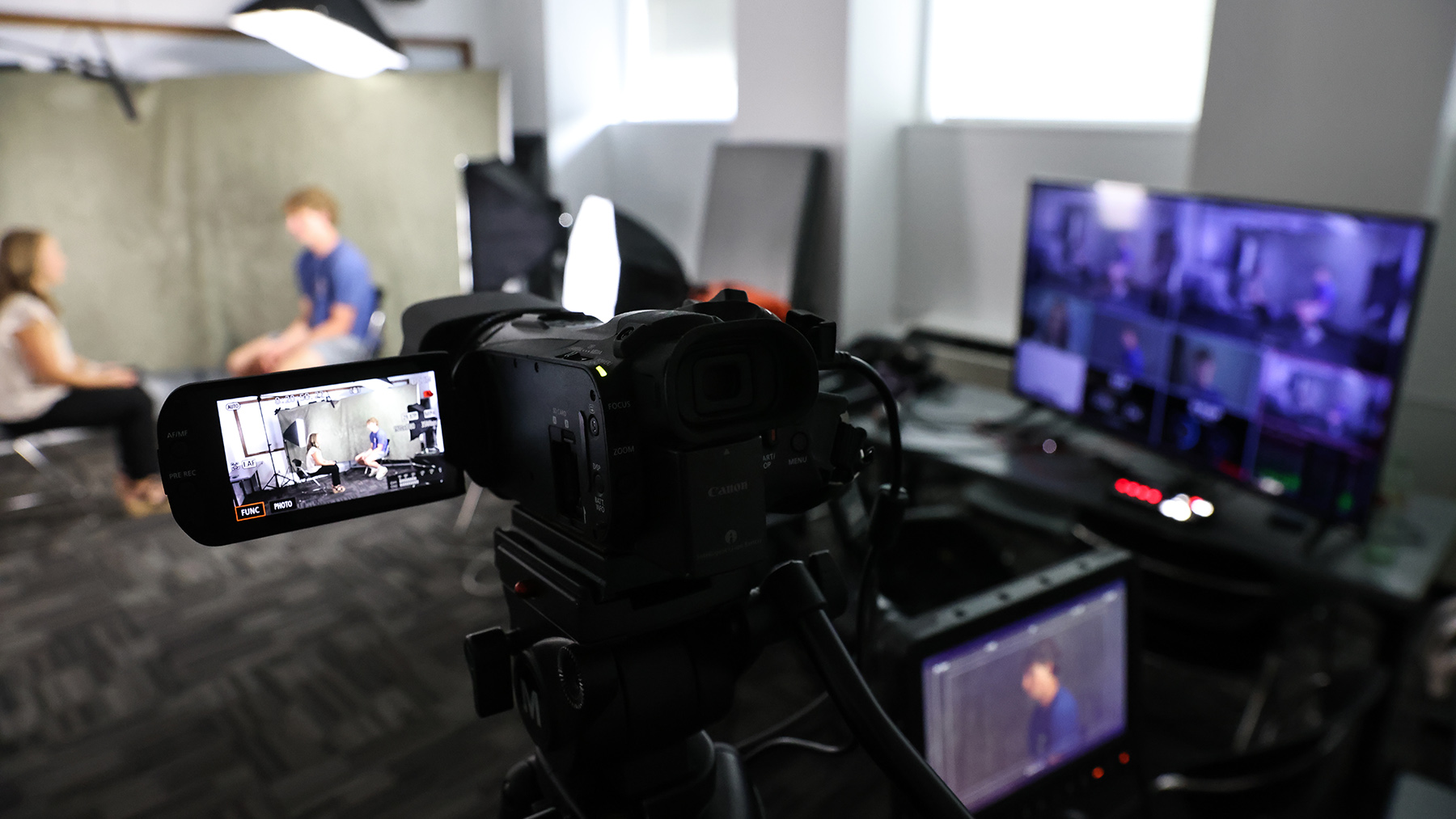 Student interviewing community member in a temporary camera studio
