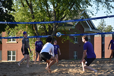 Students play sand volleyball
