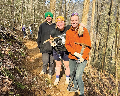 Taylor Busch ’24 and Audrey Pagel ’24, co-coordinators of Alternative Spring Break, and Sophia Perry ’24 (from left) take a break from building their small section of the Cumberland Trail.