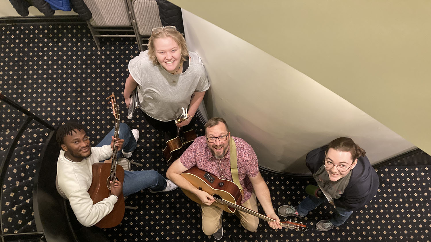 Three students and their voice instructor pose with their instruments.