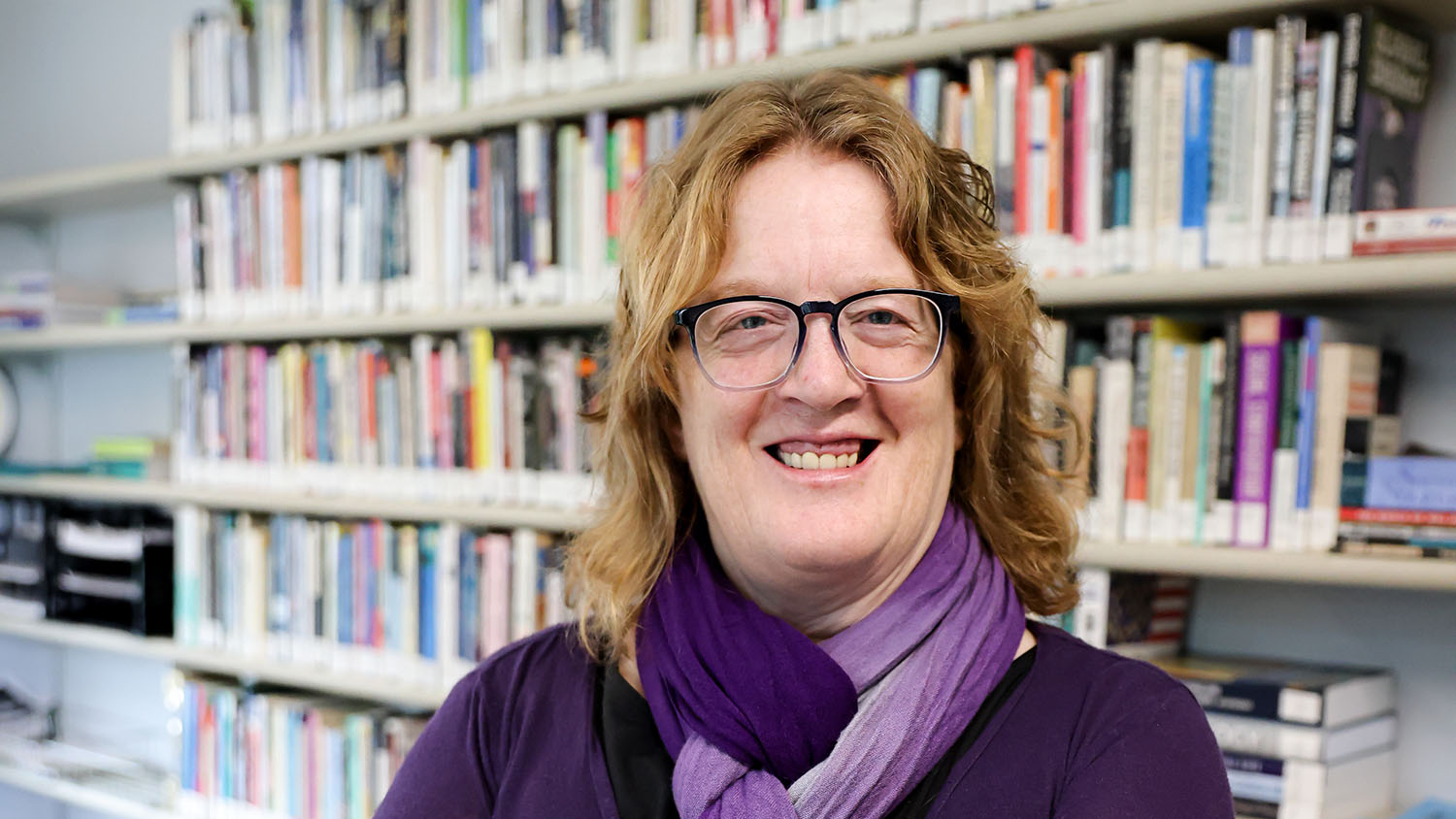 Professor of Sociology Erin Davis poses in front of a bookshelf.