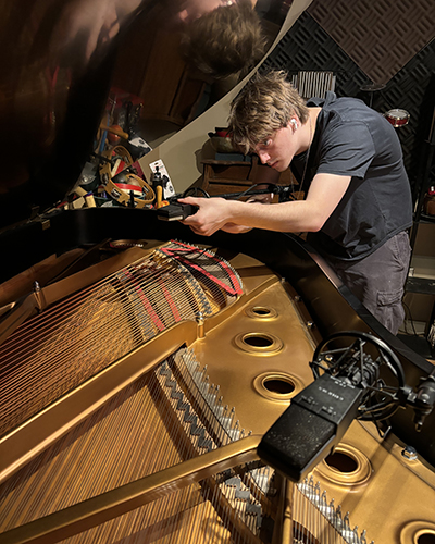 Lewis Fawcett ’26 places microphones in a Steinway grand before recording a piece he had been working on during his internship at a recording studio in New York. 