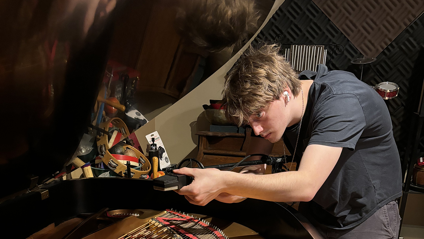 Lewis Fawcett ’26 places microphones in a Steinway grand before recording a piece he had been working on during his internship at a recording studio in New York.