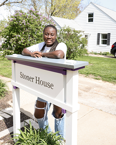 Rachael stands behind a white sign on campus.