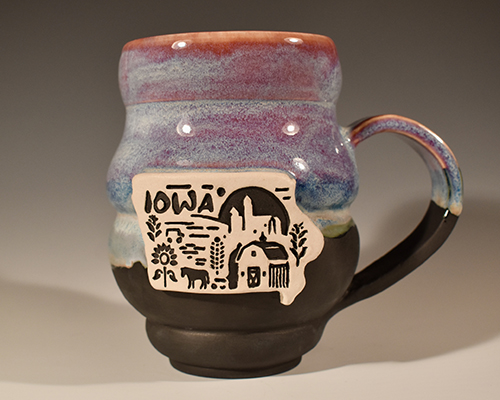 A ceramic mug with the word "Iowa" and Iowa scenics on it.