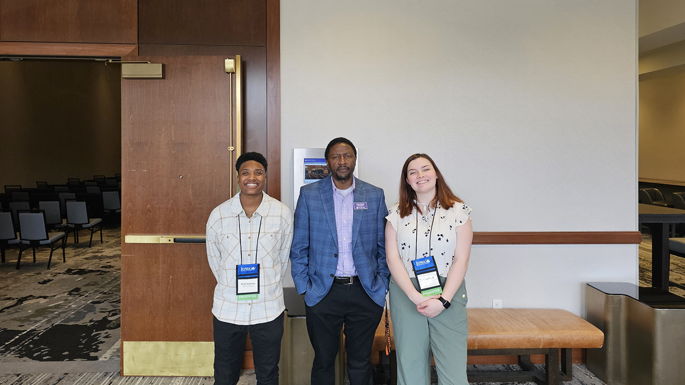 Kanyiba and two students at a conference smiling for the camera