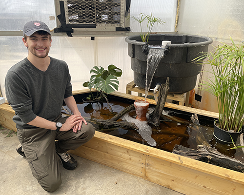 Bigalke next to the turtle pond in the greenhouse.