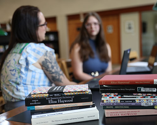 A selection of Eliza Haywood books being analyzed by Adelaide Ries '28 and Joe Wald '27.
