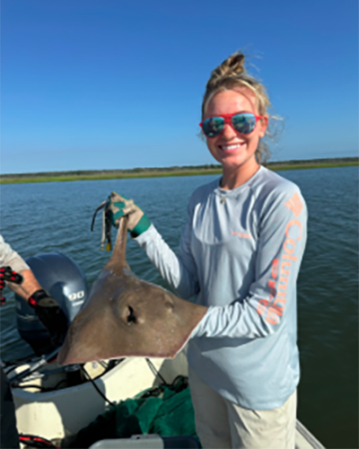 Anna Dewitt '26 holding a ray during her internship at Baruch Marine Laboratory