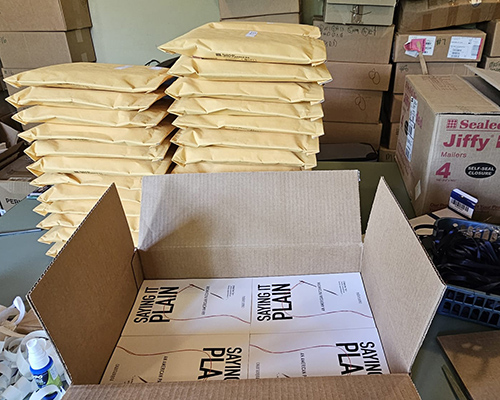 A box of books and a stack of envelopes used to make workshop packets