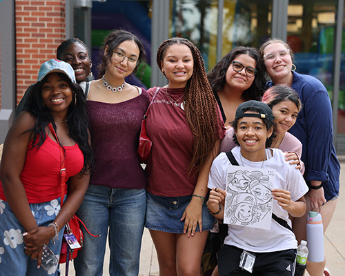 Cornell students pose together after using the caricature artist at Ramapalooza.