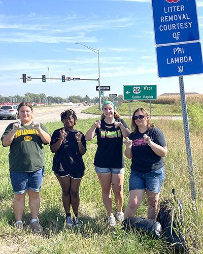 A group of Phi Lambs engaged in community service by cleaning up the litter on a highway near Cornell College.