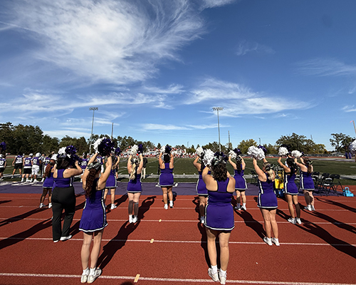 Cheerleaders yell encouragement to the football team at Homecoming 2025.