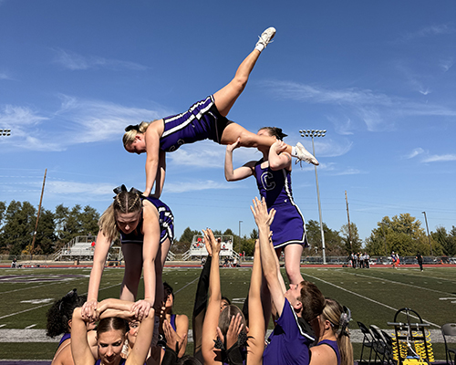 Cheerleaders perform a trick at the Homecoming 2025 football game.
