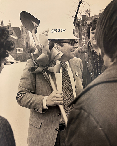 President secor with a construction hat on.