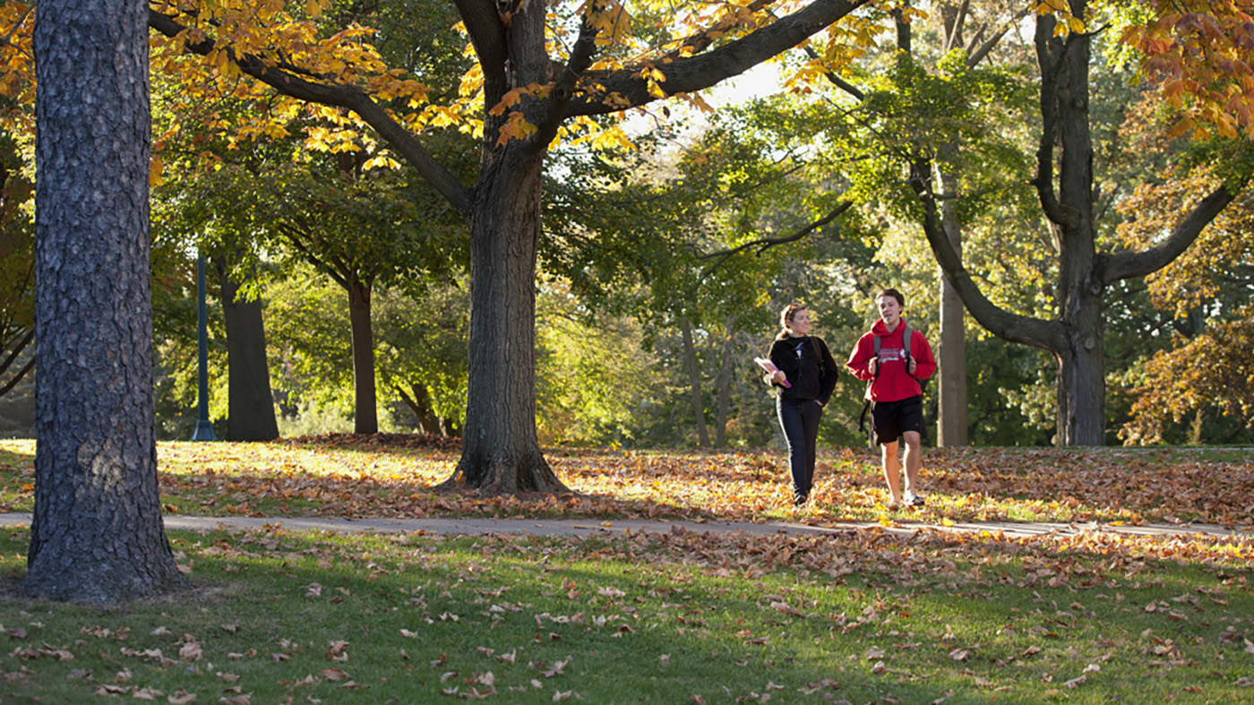 Students walking across Cornell campus in the fall.