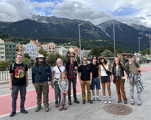 Students stand together with mountains in the background.