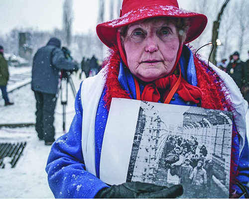 Holocaust survivor Eva Kor stands outside Auschwitz.