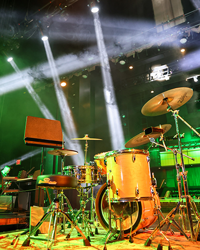 Stage lights light up a drum set.