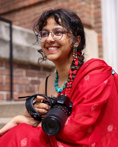 Smriti Neupane '26 sits on the steps of McWethy Hall.