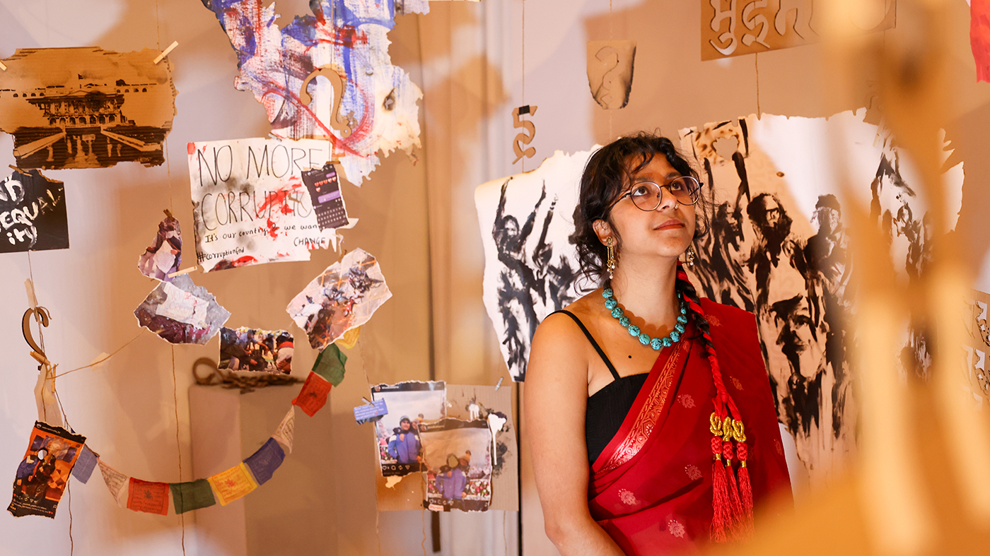 Smriti Neupane '26 examines her Senior Art Show display.