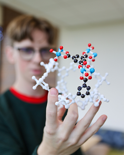JJ White holds up a 3D printed model of a metal-organic framework.