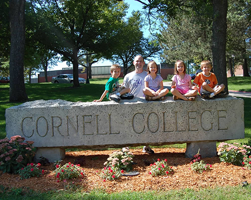 Drew Mundsinger '97 and his children pose with the Cornell College sign in 2011