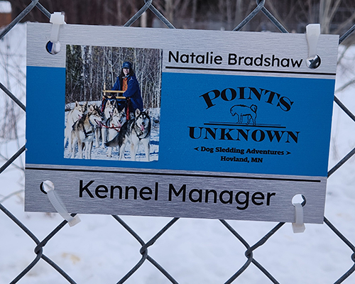 sign on the kennel that has Natalie's name and title of Kennel Manager.