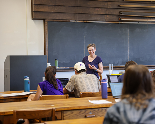 Professor teaches in front of the classroom.