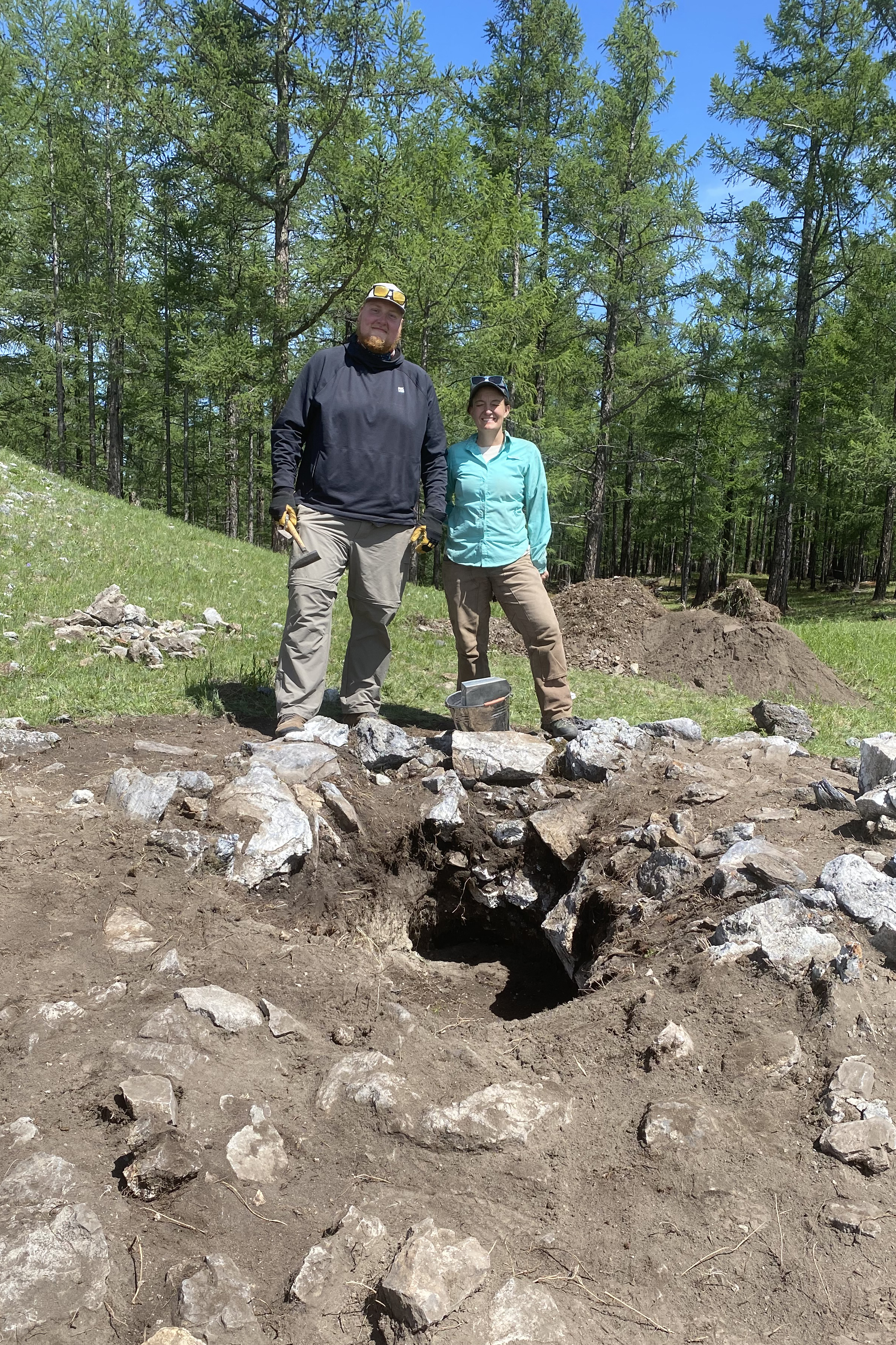 Nicholas Yelkin '25 and Julia Clark '06 stand next to a Mongolian grave they helped clean up