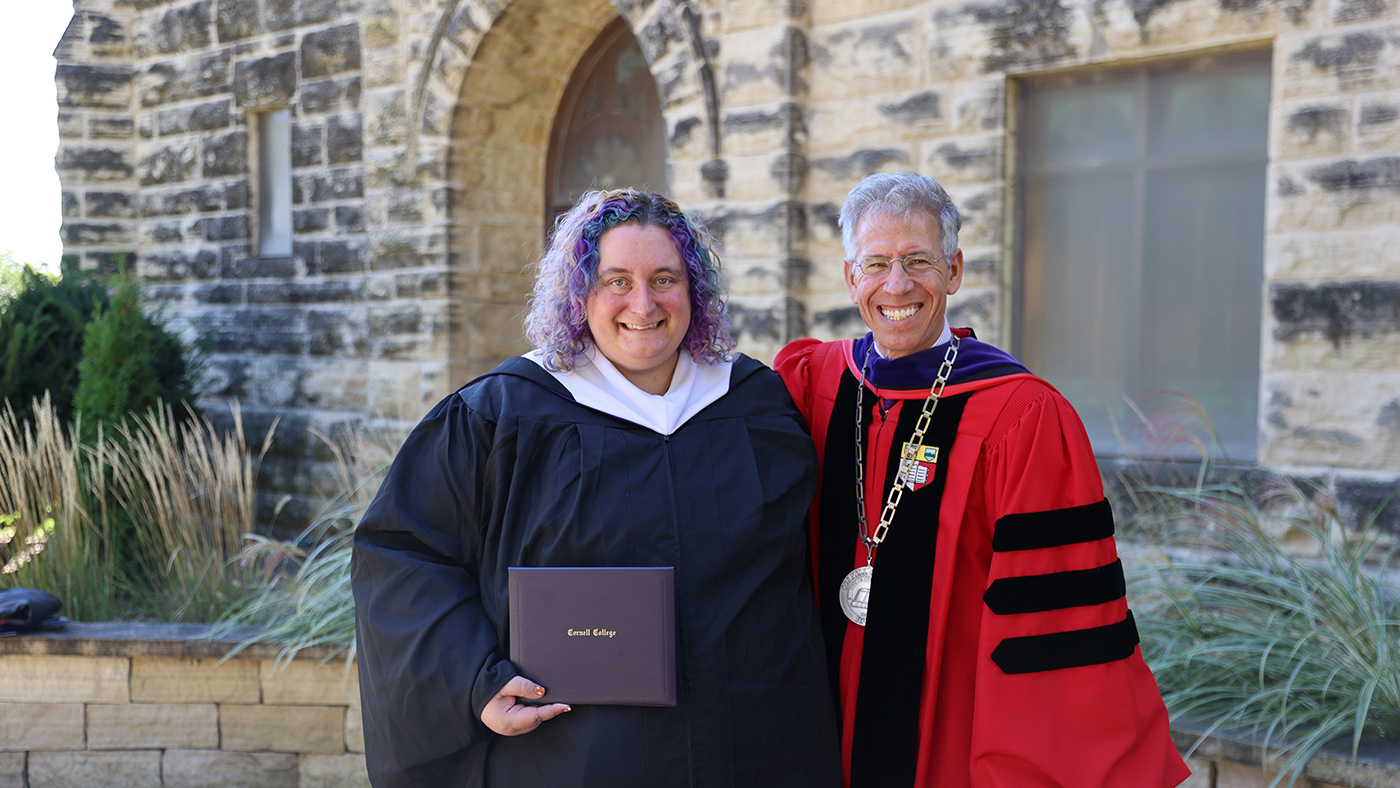 President Jonathan Brand stands with Angela Miller '13 as she holds the Young Alumni Achievement Award she received at Homecoming Weekend 2026