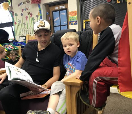 Cornell soccer player Enzo Vanzillotta ’20 reads to Tyler Teague (center) and a classmate at Washington Elementary School in Mount Vernon. 